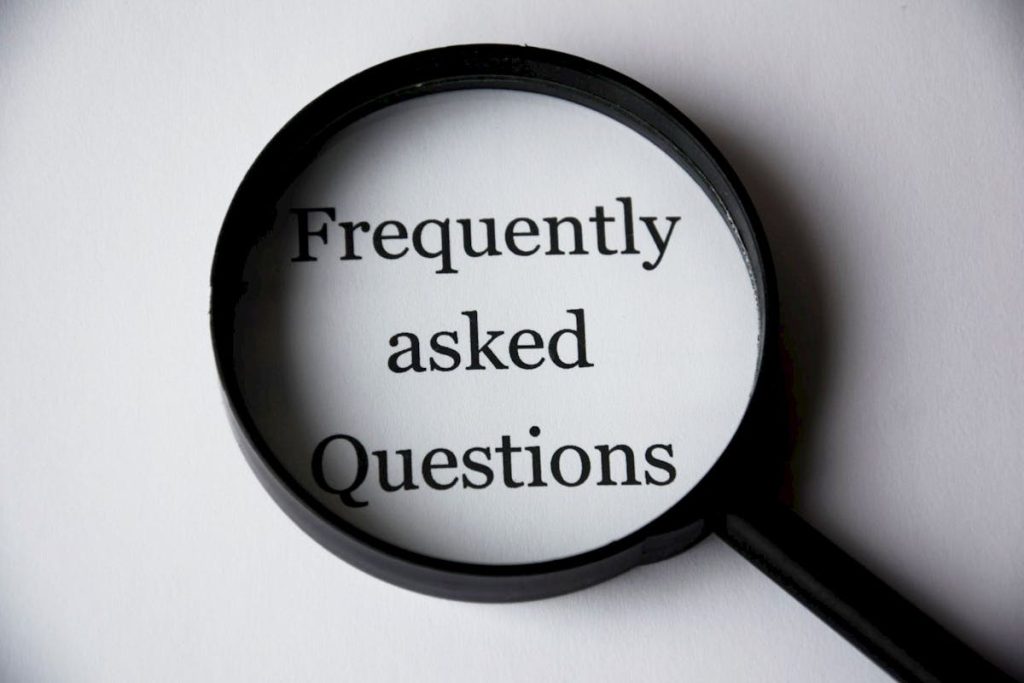 Magnifying glass highlighting the words 'Frequently Asked Questions