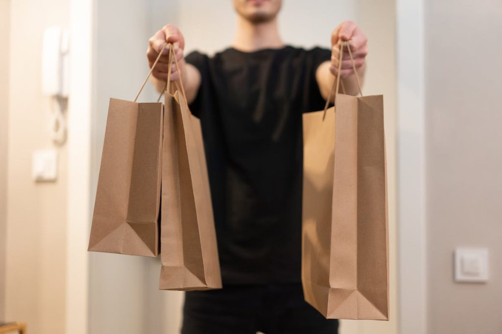 Person handing over paper bags, symbolizing how to package and present invisible skills for freelance work