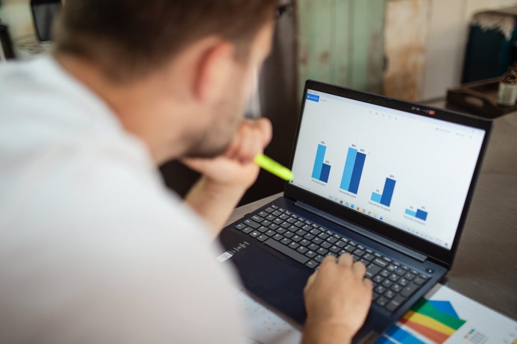 Person viewing data charts on a laptop, representing remote jobs that rely on invisible skills