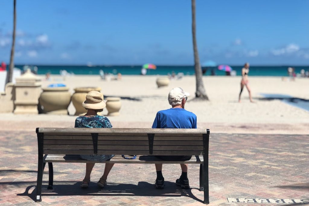 Man and woman sitting on a bench, symbolizing long-term stability through retirement investments