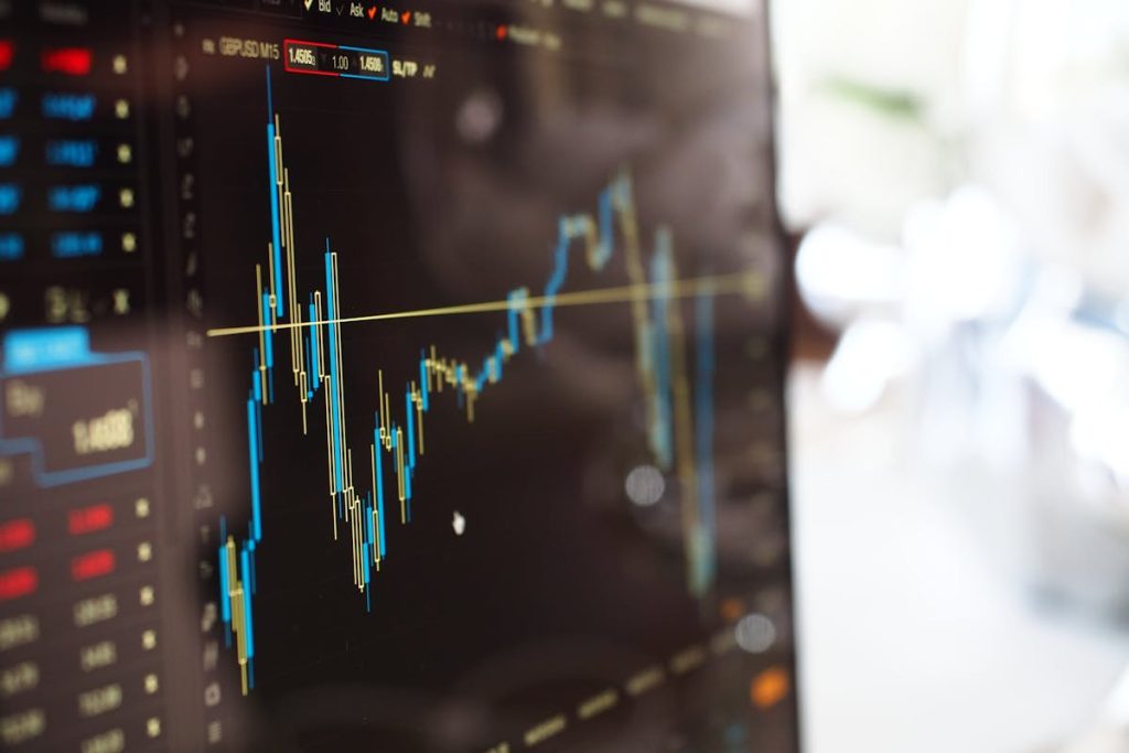 Close-up of a computer screen displaying a stock market chart with fluctuating candlestick patterns