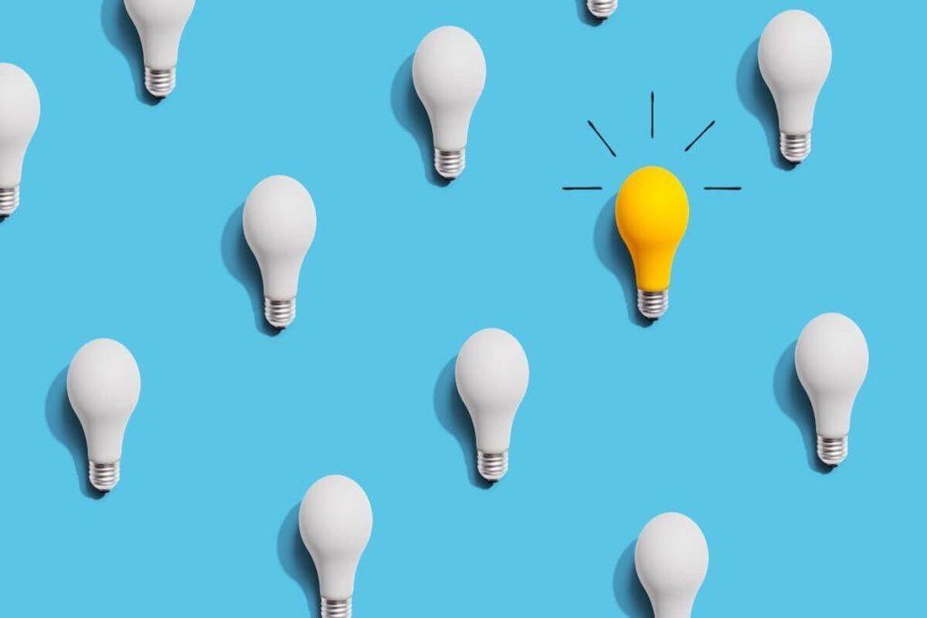 yellow lightbulb surrounded by white lightbulbs img