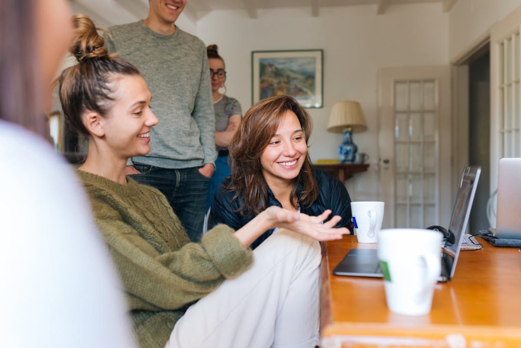 A group of people looking at laptops and smiling