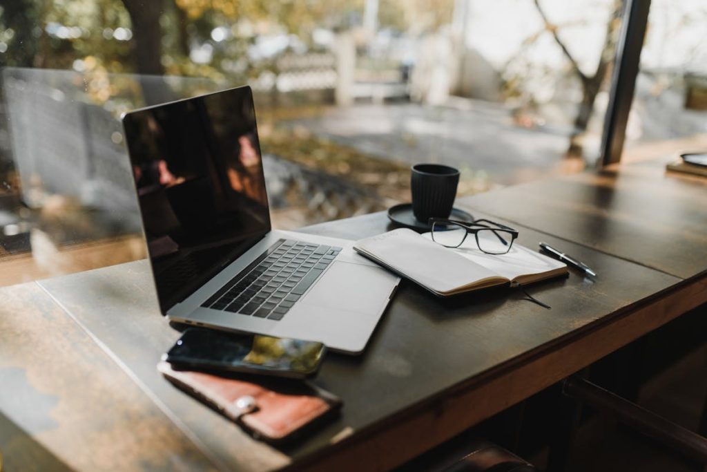 Silver laptop on brown wooden table, representing a focused workspace for weekly product development and daily quick tasks