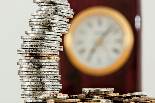 Coins stack up with a time clock behind