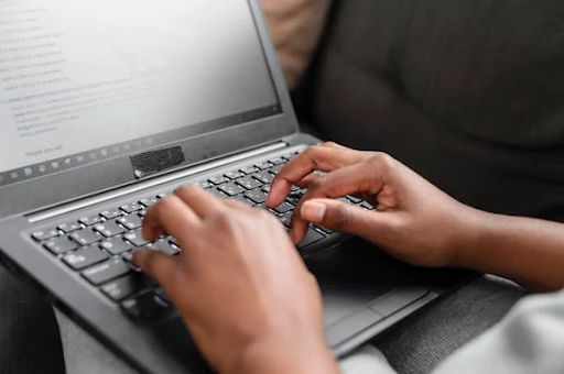 person typing on his laptop