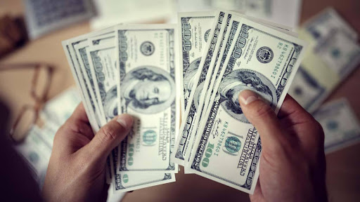 A person holding a bunch of dollars in his hands