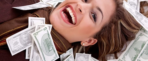 A woman smiling while lying down with bunch of cashes on her