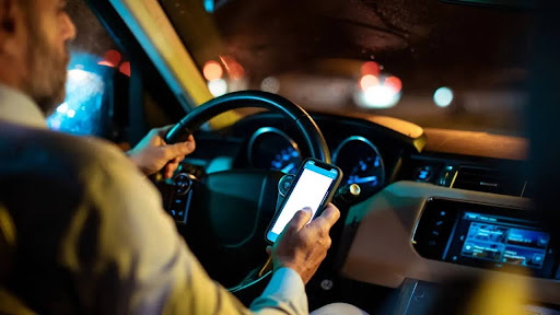 A person checking affiliate earnings on a phone while sitting in a car