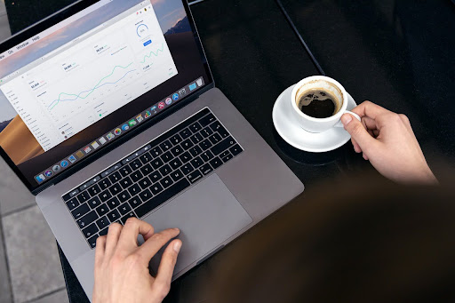 Professional updating multiple business listings on laptop with coffee on Monday morning