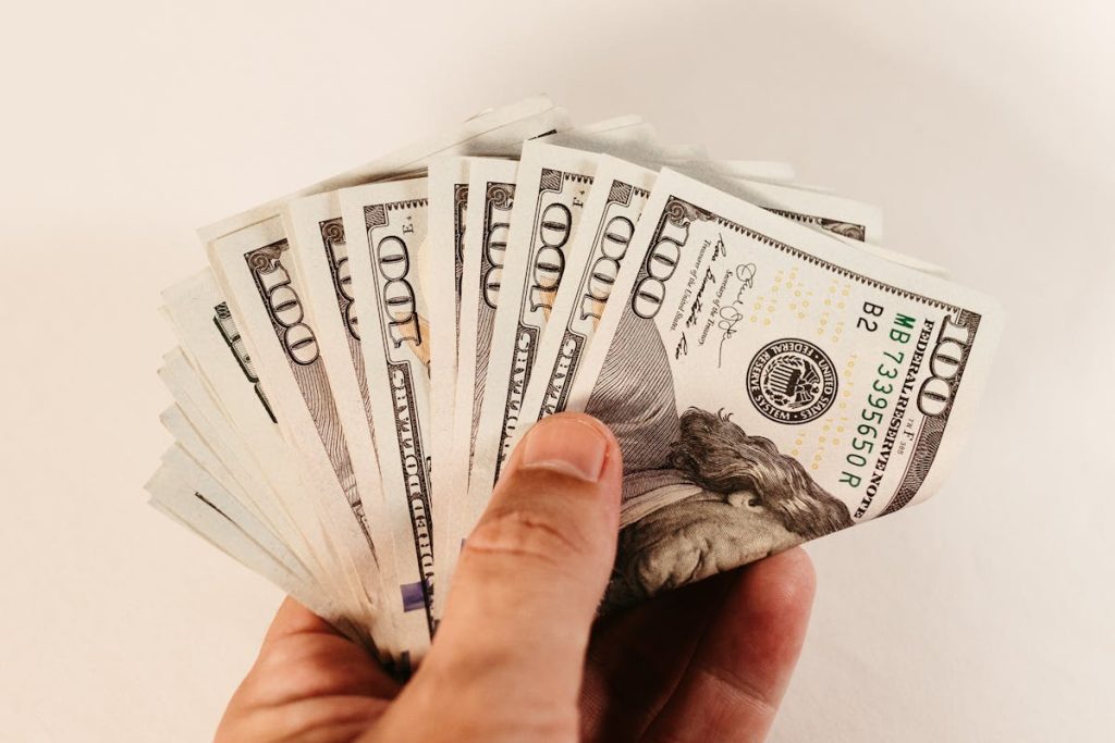 Hand holding U.S. dollar bills representing freelance income