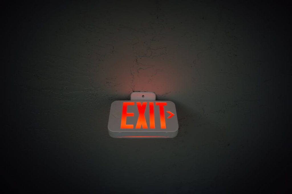 Exit sign hanging from ceiling in a public space, symbolizing job resignation