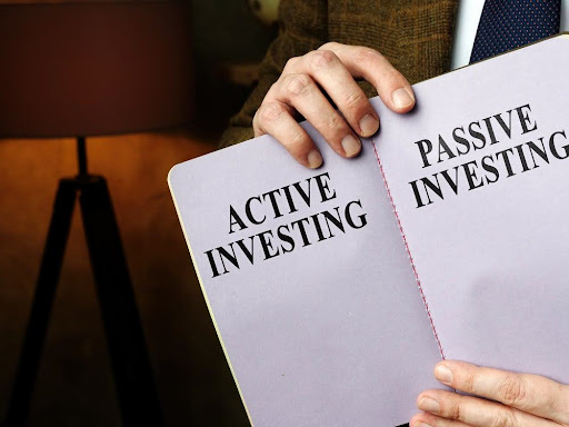 A man holding a book talking abou the difference between active investing and passive investing