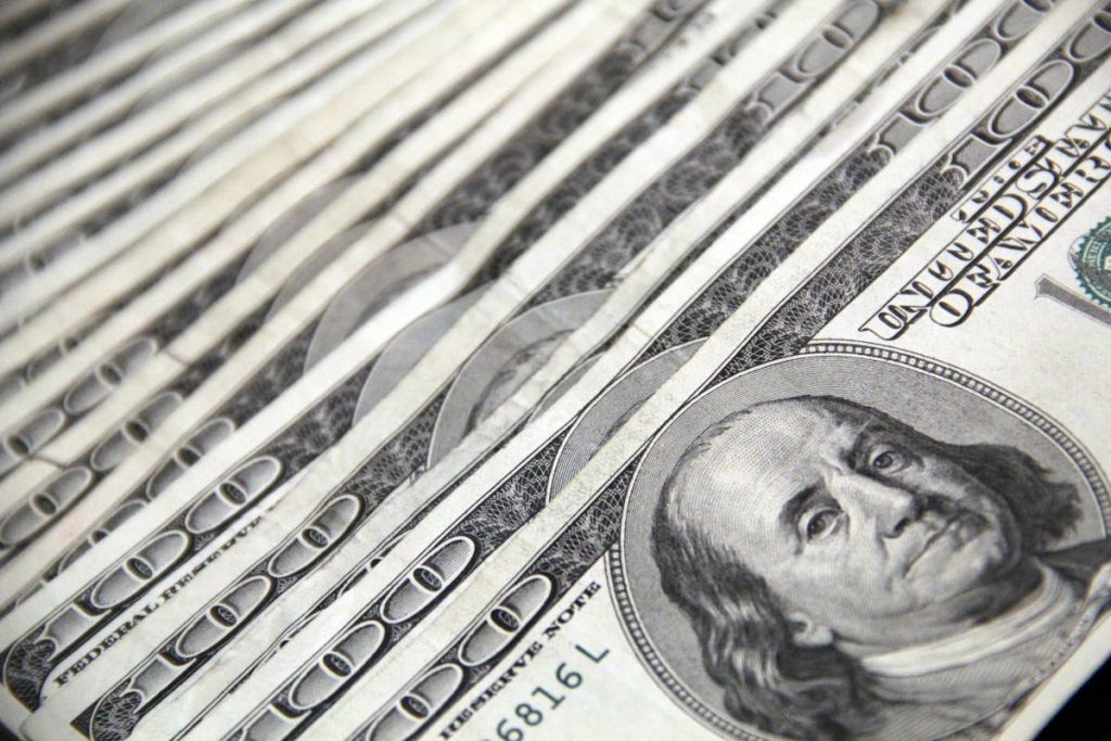 Stack of 100 US dollar bills representing side hustle income