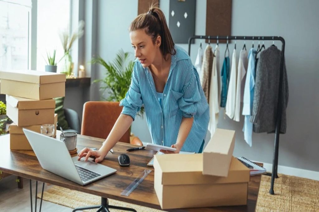 A woman focused on her laptop while seated at a desk in a modern office environment