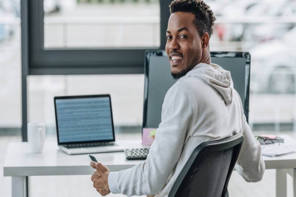 A web developer seated at a desk working on a laptop