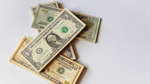 Stack of dollar bills arranged on a white background